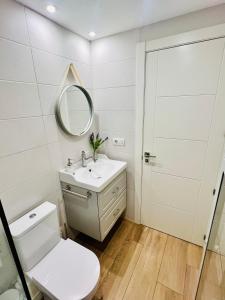 a white bathroom with a sink and a mirror at Loft de estilo industrial con garaje in Valladolid