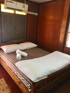 a bed in a room with two pillows on it at Baan Fun Dee Chiang Khan in Chiang Khan