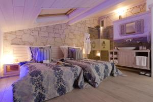 a bedroom with two beds and a stone wall at Cella Hotel & SPA Ephesus in Selcuk