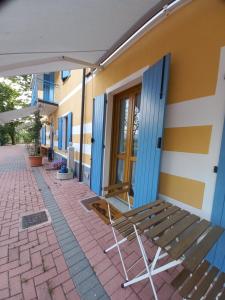 a bench next to a building with blue doors at AGRICOLA GODINO B&B in Ozzano Monferrato