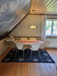 uma sala de jantar com mesa e cadeiras em Lägenhet på hästgård em Ljungbyhed