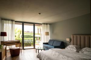 ein Schlafzimmer mit einem Bett, einem Stuhl und einem Fenster in der Unterkunft Hotel Muchele in Meran