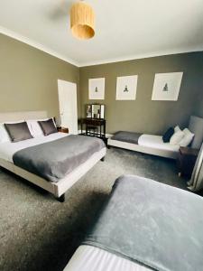 a bedroom with two beds and a couch at The Woodlands - Zillo in Bishop Auckland