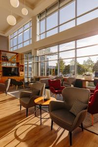 a lobby with chairs and tables and large windows at Holiday Inn Belgrade, an IHG Hotel in Belgrade