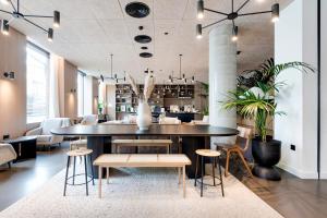 un restaurant avec une grande table et des chaises noires dans l'établissement Gravity Camden Lock Apartments, à Londres