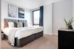 - une chambre avec un grand lit et une fenêtre dans l'établissement Gravity Camden Lock Apartments, à Londres