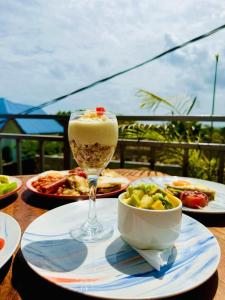 a table with a drink and a bowl of food at Mangi Mangi Accomodation in Nungwi