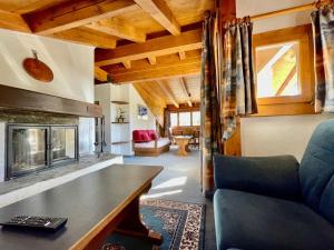 sala de estar con sofá y chimenea en Hotel Chesa Grischa, en Sils Baselgia