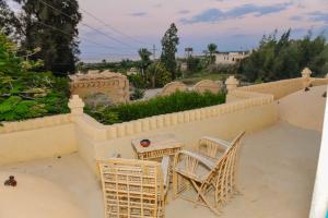 a patio with chairs and a table on a wall at Tunis village in Tunis