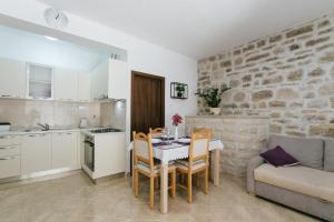 eine Küche und ein Wohnzimmer mit einem Tisch und Stühlen in der Unterkunft Apartment Dajana near the beach in Kaštela