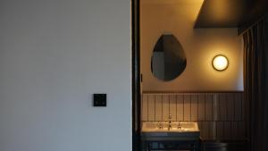 a bathroom with a sink and a mirror on the wall at 彼厅酒店Hotel in between in Changsha