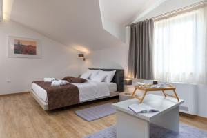a white bedroom with a bed and a table at Family villa Filton with wellness in Vizinada in Vranje Selo +69 photos