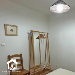 Cette chambre comprend un miroir, une chaise et une lampe. dans l'établissement A casa da avó Mina, à Sabugal