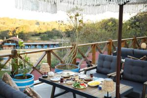a table with food on top of a balcony at MAVİ AT HOTEL Blue Horse in Gümüşdere
