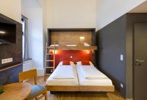a bedroom with a bunk bed and a table at JUFA Hotel Spital am Pyhrn in Spital am Pyhrn