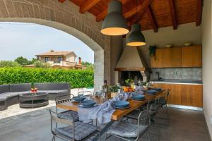a dining room table with chairs and a kitchen at Family villa Maria with pool in Vizinada in Vranje Selo