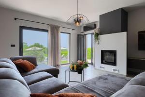a living room with a couch and a fireplace at Family villa Maria with pool in Vizinada in Vranje Selo