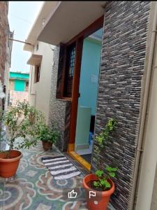 a brick building with potted plants on a patio at Hampi Soni Family Homestay in Hospet
