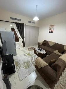 a living room with a couch and a flat screen tv at شقق فندقيه in Dubai