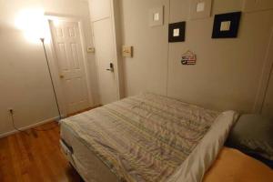 a small bedroom with a bed and a door at Cozy room at great Townhouse in Williamsburg in Brooklyn