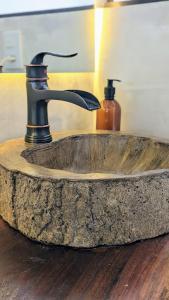 un lavandino in pietra con un rubinetto sopra di Catalina Hotel a Ubatuba