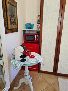 Porto Columbu - Perdʼe SaliにあるVilla Dollyの小さなテーブル(赤い電子レンジ付)とテーブル(テーブル・シドックス・シドックス)