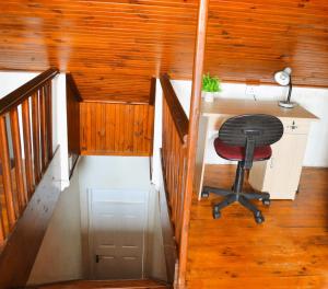 a desk and a chair in a room with wooden walls at 149 ROCHESTER ROAD. OBSERVATORY in Cape Town