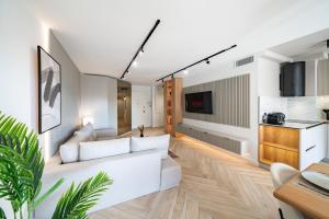 a living room with a white couch and a kitchen at Luxueux appartement - Vue mer - Parking - AZ in Beausoleil