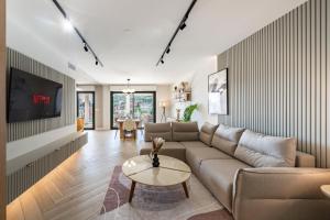 a living room with a couch and a tv at Luxueux appartement - Vue mer - Parking - AZ in Beausoleil