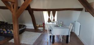 ein Esszimmer mit einem Tisch, einem weißen Tisch und Stühlen in der Unterkunft Chambres d'hôtes chez Sylvie in Donnemain-Saint-Mamès