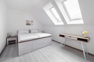 łóżko i biurko w pokoju z świetlikami w obiekcie Apartmán Jasmin w mieście Frymburk
