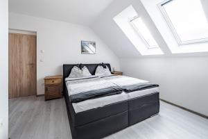 sypialnia z łóżkiem z białymi ścianami i świetlikami w obiekcie Apartmán Jasmin w mieście Frymburk +29 zdjęć