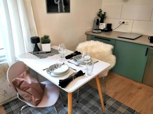 a white table with plates and glasses on it in a kitchen at Der schönste Platz in der Altstadt in Amberg