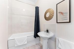 ein weißes Badezimmer mit einem Waschbecken, einer Badewanne und einem WC in der Unterkunft Exquisite Flat - Parking - Sleeps 9 in Bristol