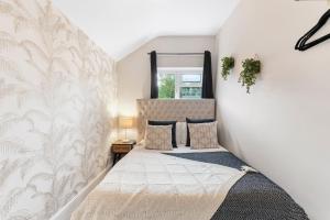 1 dormitorio con 1 cama con pared blanca en Lovely 2 bedroom apartment - Sleeps 9, en Bristol