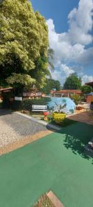 a pool with a green floor and a bench at Pousada Rancho do João in Pirenópolis