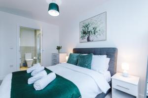 a bedroom with a large white bed with green sheets and pillows at NEW! Stylish 2-bed apartment in Manchester by 53 Degrees Property - Amazing location, Ideal for Small Groups - Sleeps 4! in Manchester