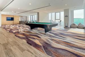 een pooltafel in een grote kamer met een tapijt bij Frank Porter - 1 Residences Al Wasl in Dubai
