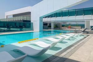 een zwembad met een rij stoelen in een gebouw bij Frank Porter - 1 Residences Al Wasl in Dubai