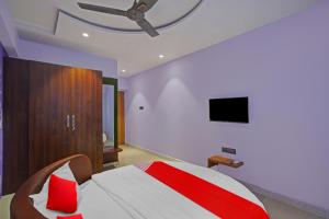 a bedroom with a bed with a ceiling fan at Flagship Hotel Happy Stay in Surat