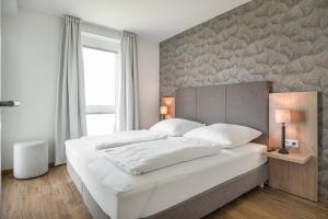 ein Schlafzimmer mit einem großen weißen Bett mit einer Wand in der Unterkunft Ostseebrise Olpenitz in Olpenitz