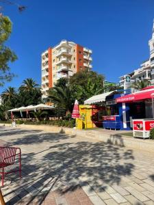 a park with a bench and buildings in a city at Seaside Gem in Sarandë +25 photos