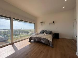 a bedroom with a bed and a large window at Madrid Living - Cuatro Vientos in Madrid