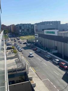 una calle de la ciudad con coches aparcados en un estacionamiento en Madrid Living - Cuatro Vientos en Madrid