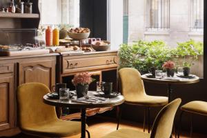 - une cuisine avec deux tables, des chaises et une cuisinière dans l'établissement Albert's Hotel, à Paris