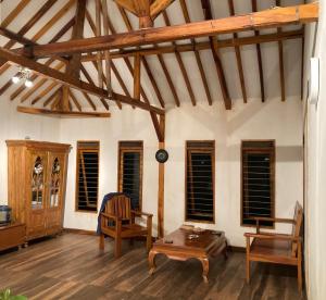 salon z drewnianymi podłogami i drewnianymi belkami stropowymi w obiekcie B&B Family Farmhouse w mieście Cikelet