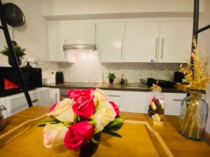 a kitchen with red roses in a vase on a table at Appartement Ostend in Ostend