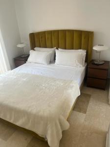 ein Schlafzimmer mit einem großen weißen Bett mit zwei Nachttischen in der Unterkunft Villa puerto banuus Marbella in Marbella