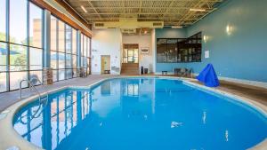 una gran piscina con agua azul en un edificio con ventanas en Aviator Hotel & Suites South I-55, BW Signature Collection, en Green Park