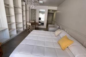 1 cama blanca grande con almohada amarilla en una habitación en Belgrano chic, Echeverría y Arcos en Buenos Aires